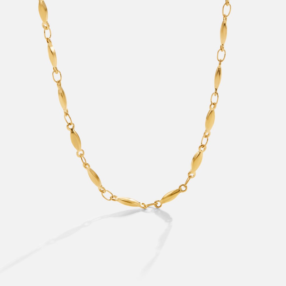 Magdalena – Tunt gold necklace with discreet rings.