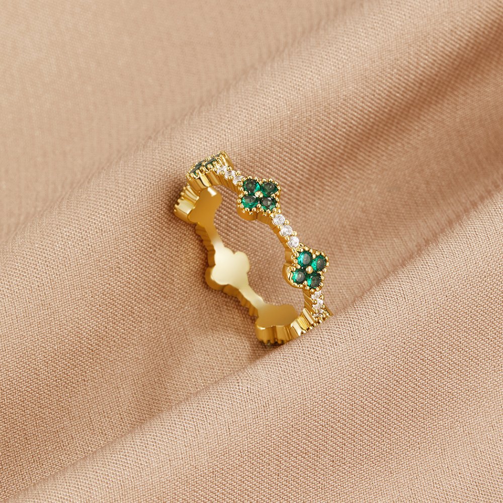 Annika – Gold ring with floral details and emerald accents.