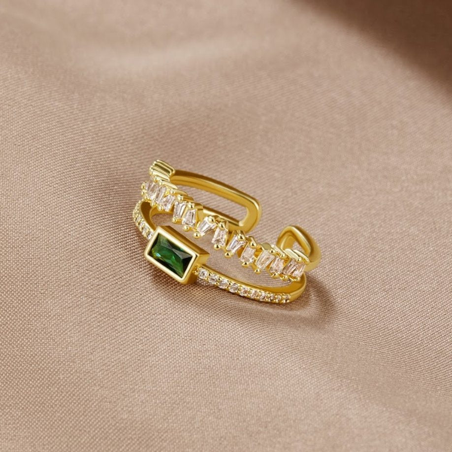Sabina – Gold ring with green emerald details.